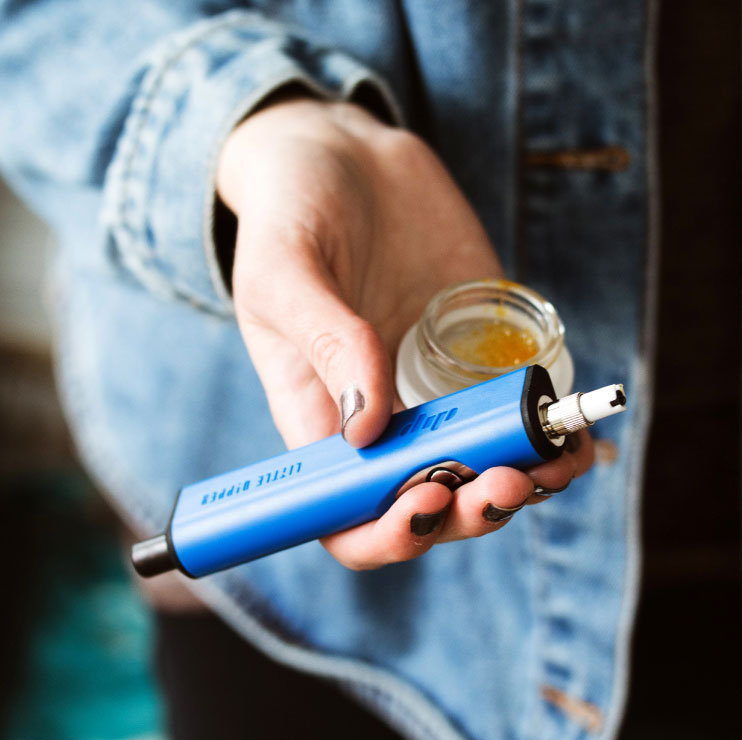 Person Holding a Vape and Jar in their Hand Person Holding a Vape and Jar in their Hand